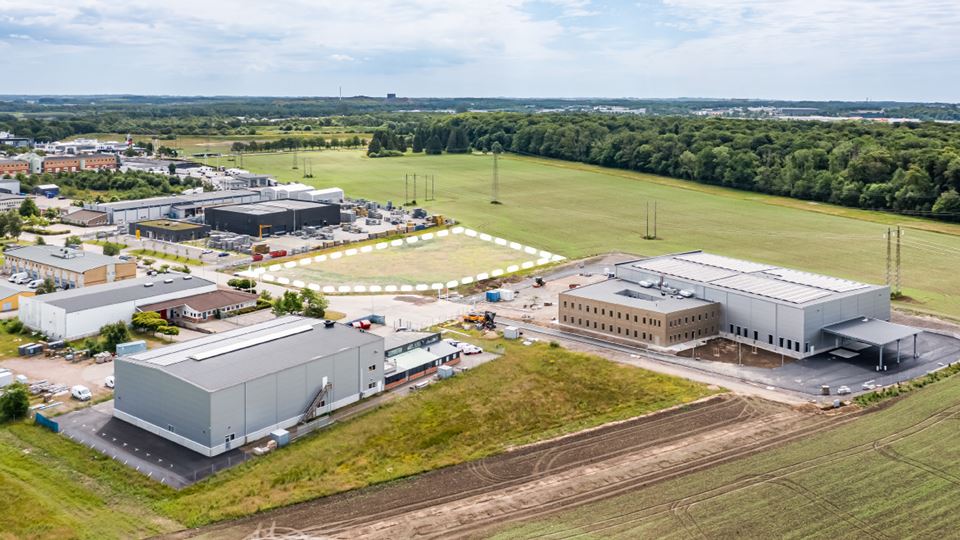 Flygvy över en produktionsanläggning i grått med stora körytor, Snårskogen 5 i Helsingborg.