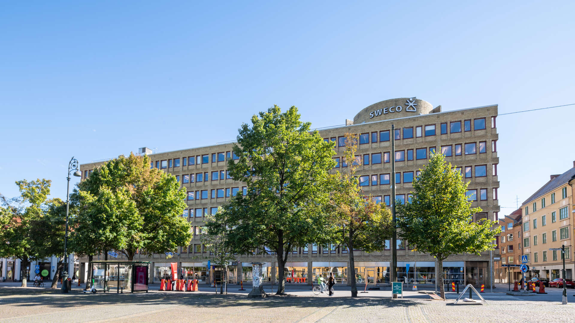 Österport 7, en gul kontorsfastighet, med Drottningtorget i förgrunden.