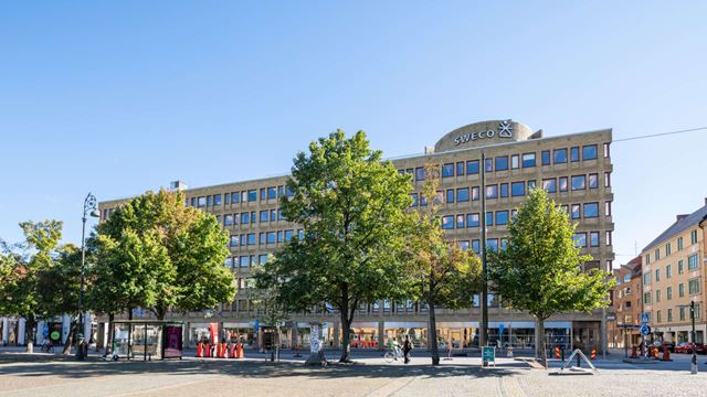 Österport 7, en gul kontorsfastighet, med Drottningtorget i förgrunden.