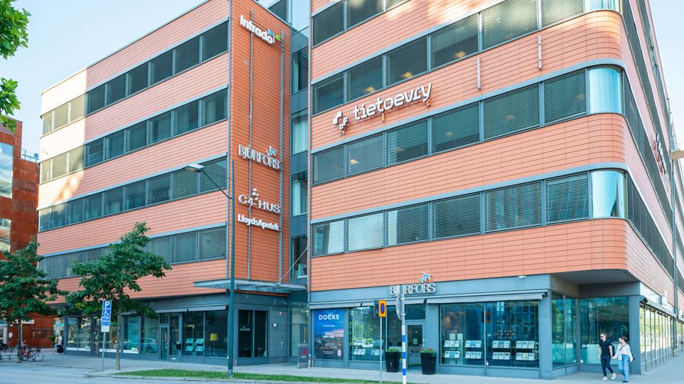 Fastighet med röd fasad och stora glasytor i Skrovet 5.