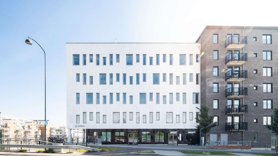 Vit och grå modern kontorsbyggnad i flera plan, Raffinaderiet 5 (Sockerbiten), fastighet med moderna kontorslokaler på Kung Oskars väg 11 vid Lund C.