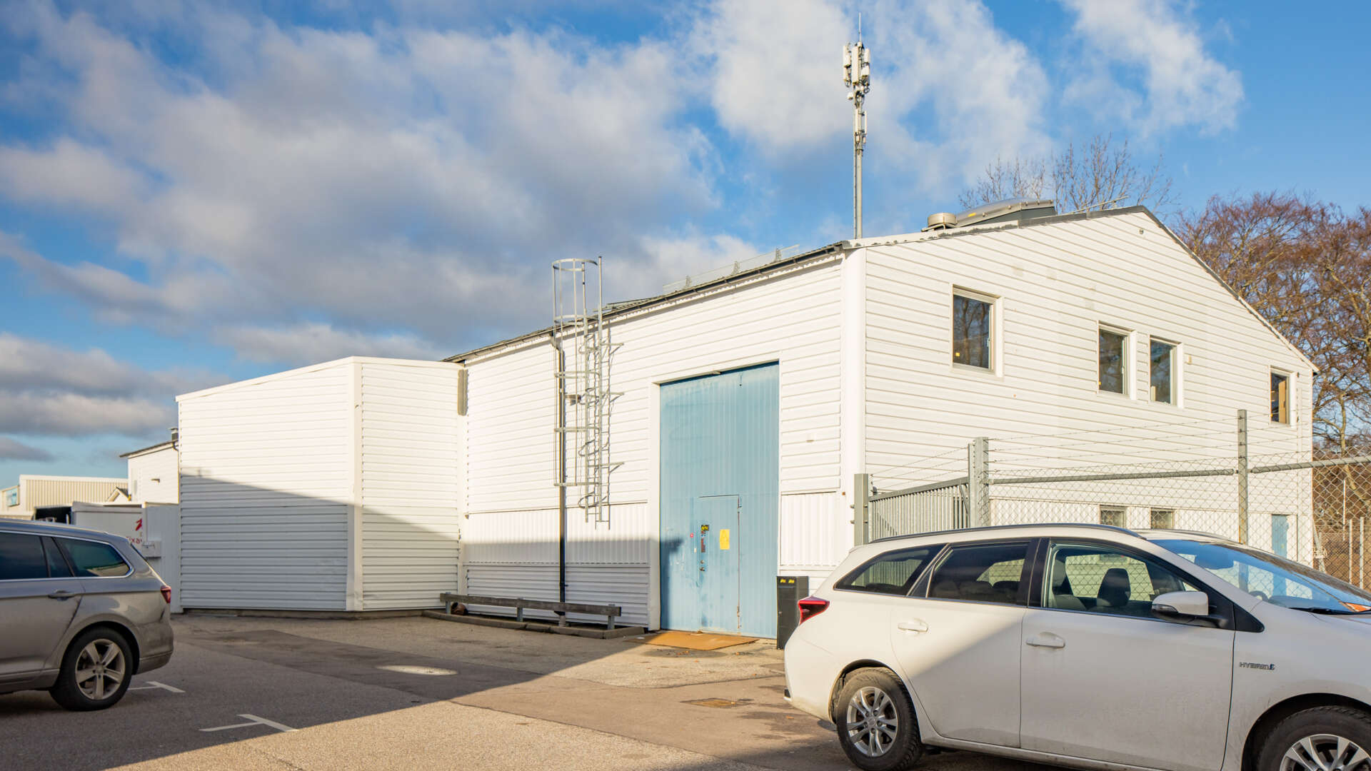Vit industribyggnad med lastport och stängsel, Balken 7 i Limhamn,